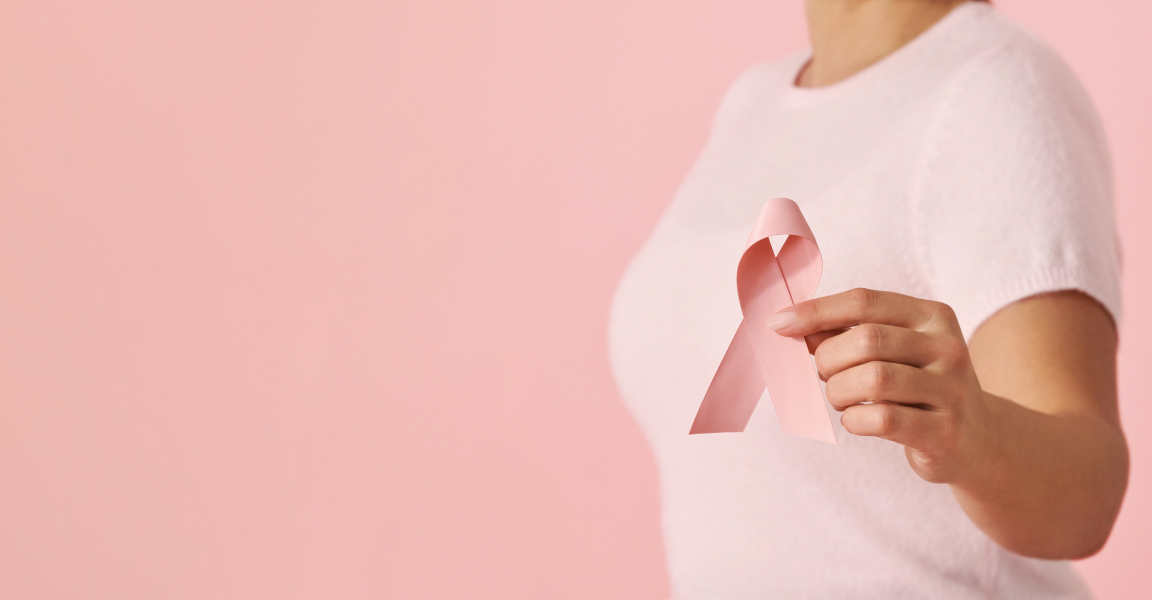 Model holding a pink ribbon symbol of breast cancer awareness