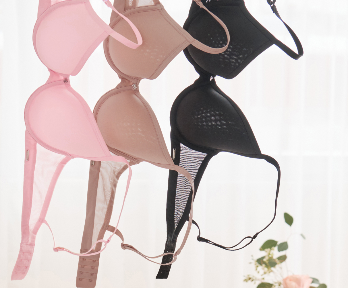 Trois soutien-gorges suspendus : un rose, un beige et un noir