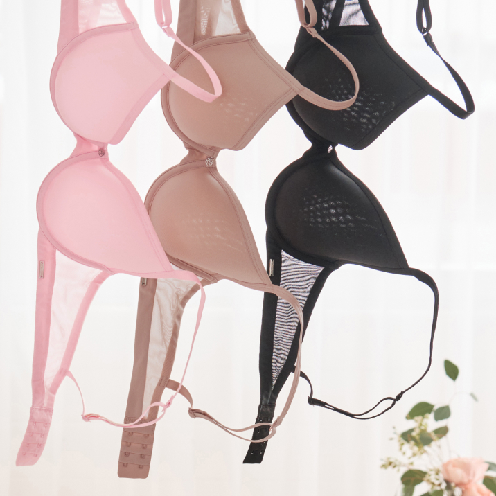 Trois soutien-gorges suspendus : un rose, un beige et un noir