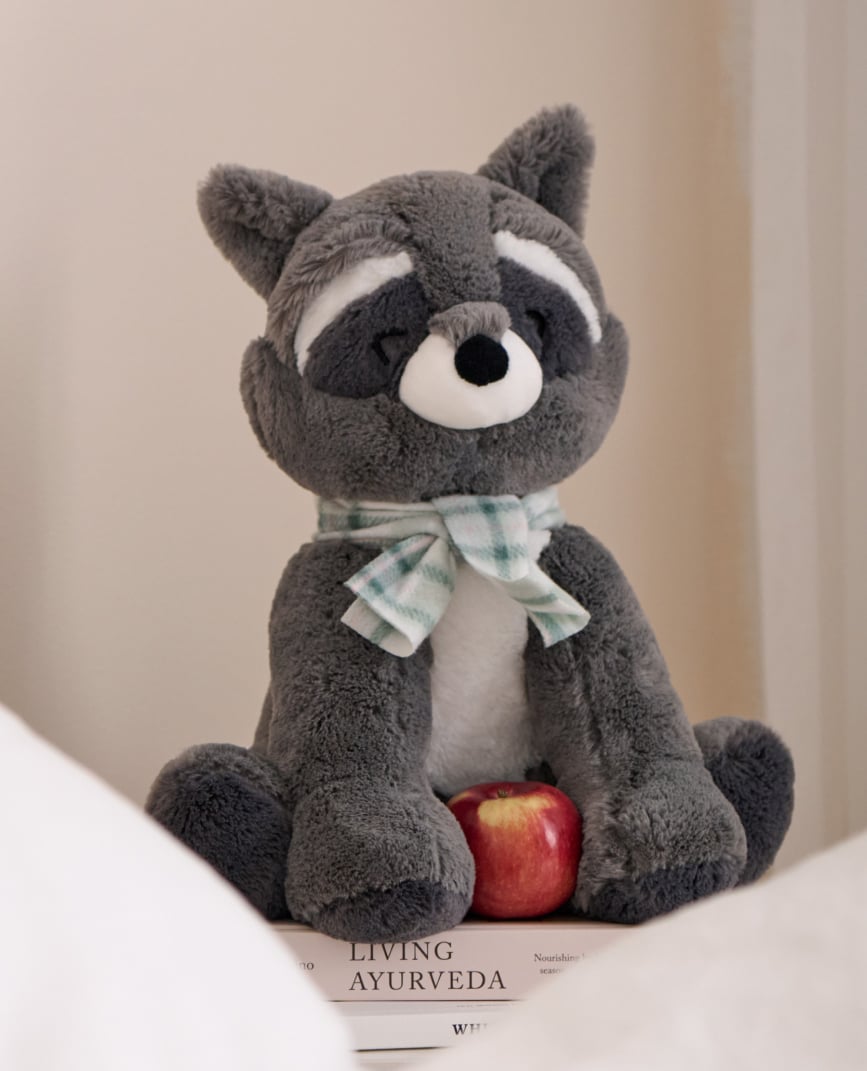Grey raccoon plush with checkered scarf.