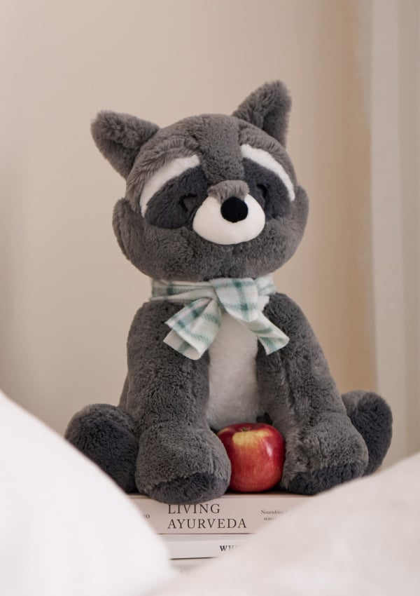 Grey raccoon plush with checkered scarf.