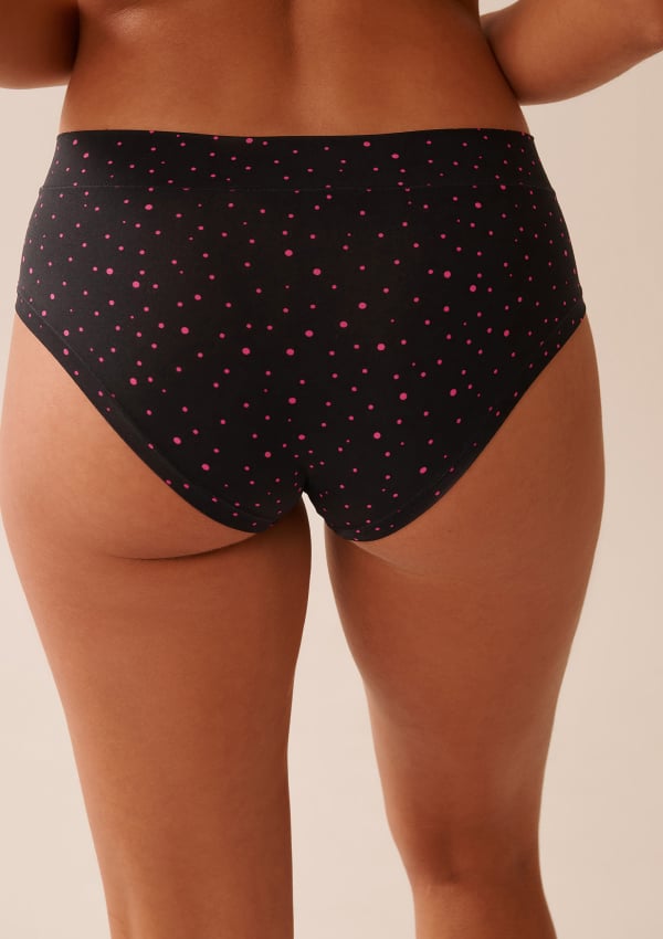 Back view of black panties with pink polka dots worn by model.