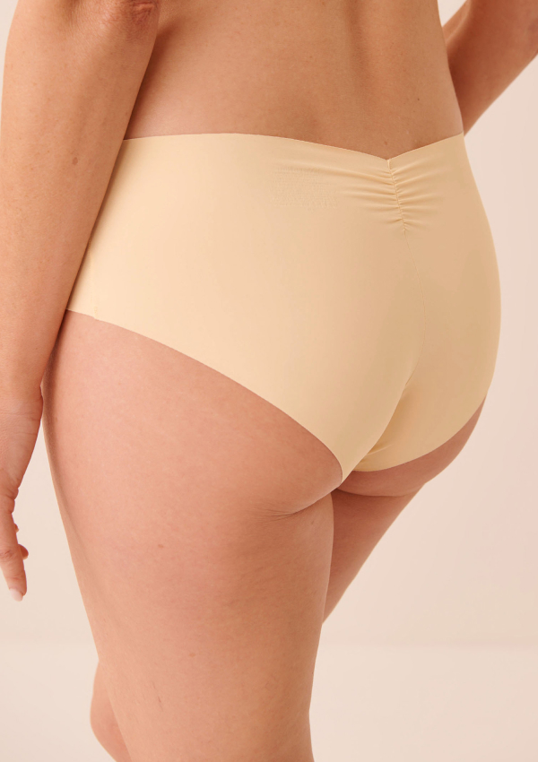 Model shown from the front wearing red panties with black floral patterns.