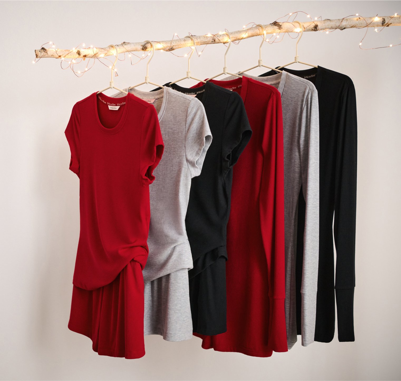 Ribbed modal pajamas in red, grey, and black hanging on a wooden rack.