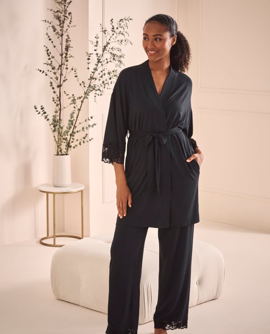 Mannequin portant un kimono noir fermé avec un pantalon assorti.