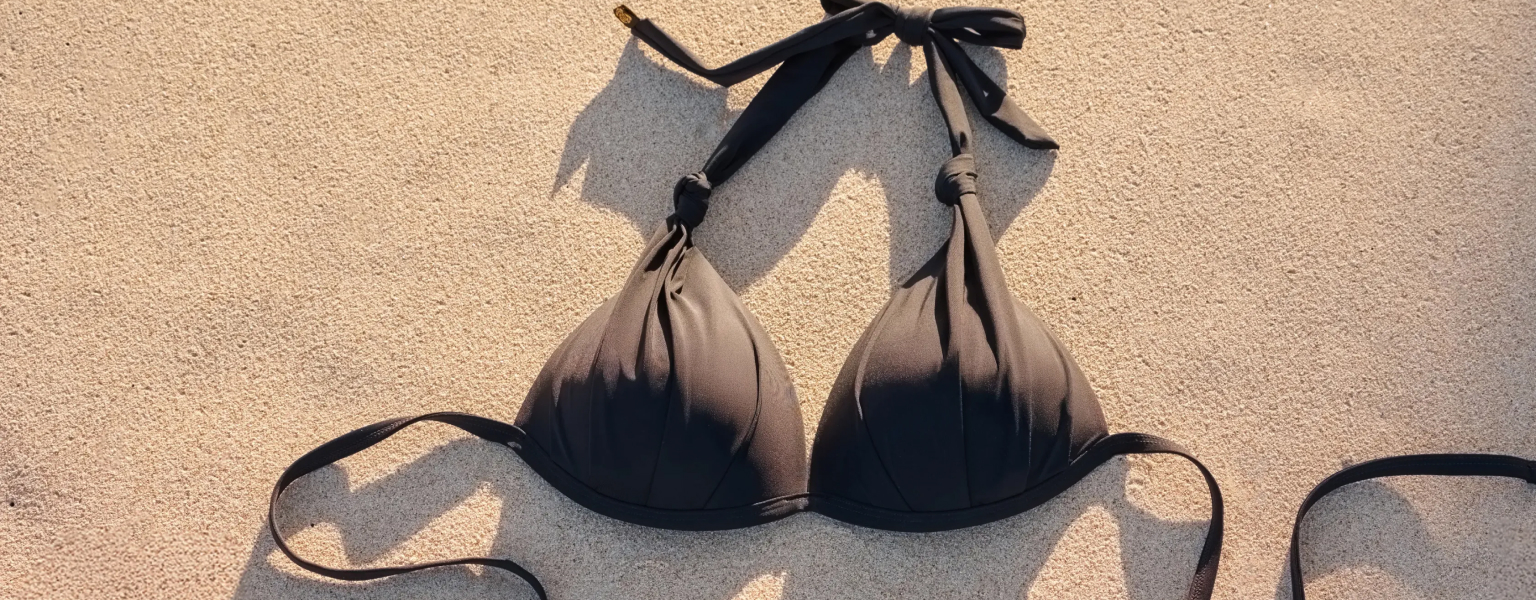 Black convertible bikini top resting on the sand