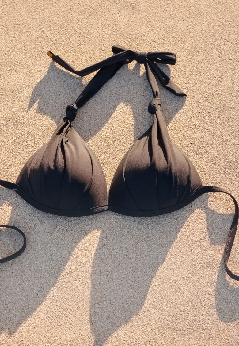 Black convertible bikini top resting on the sand