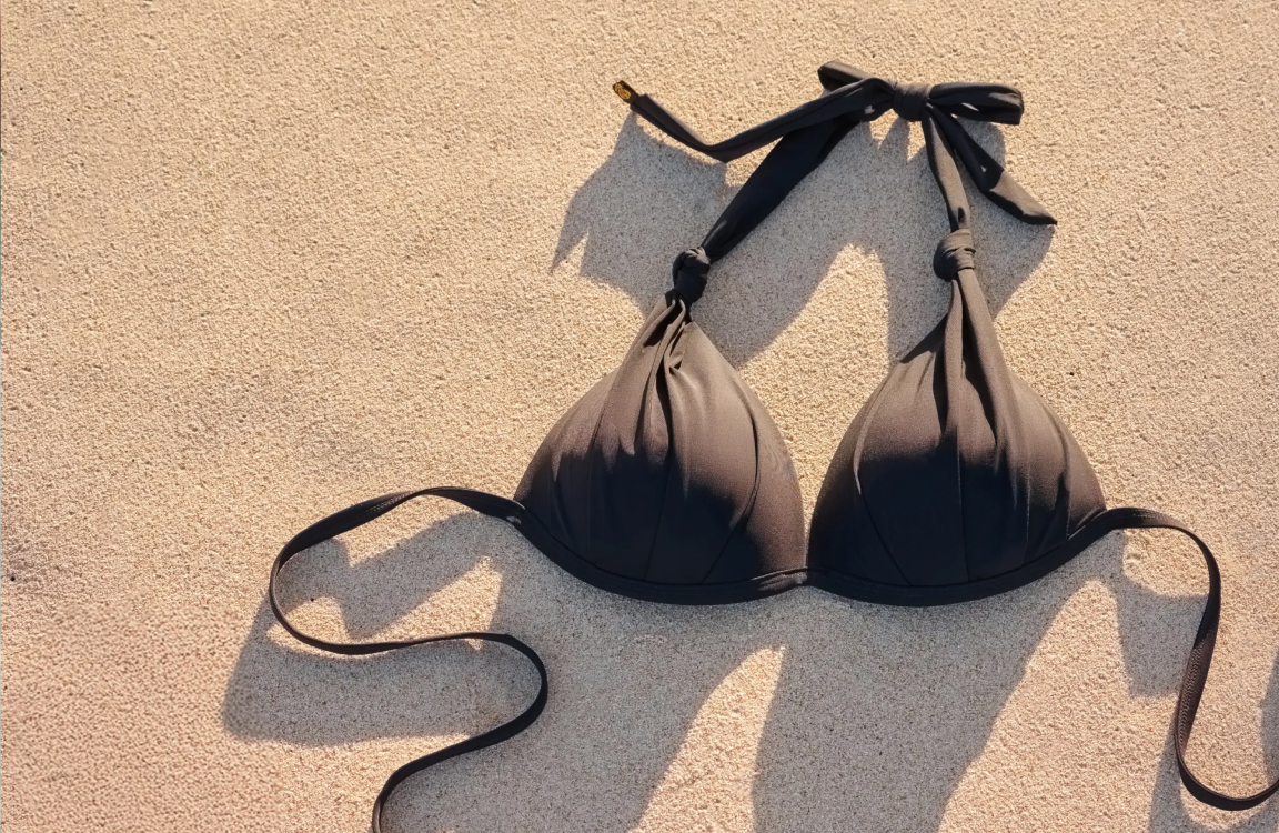 Black convertible bikini top resting on the sand