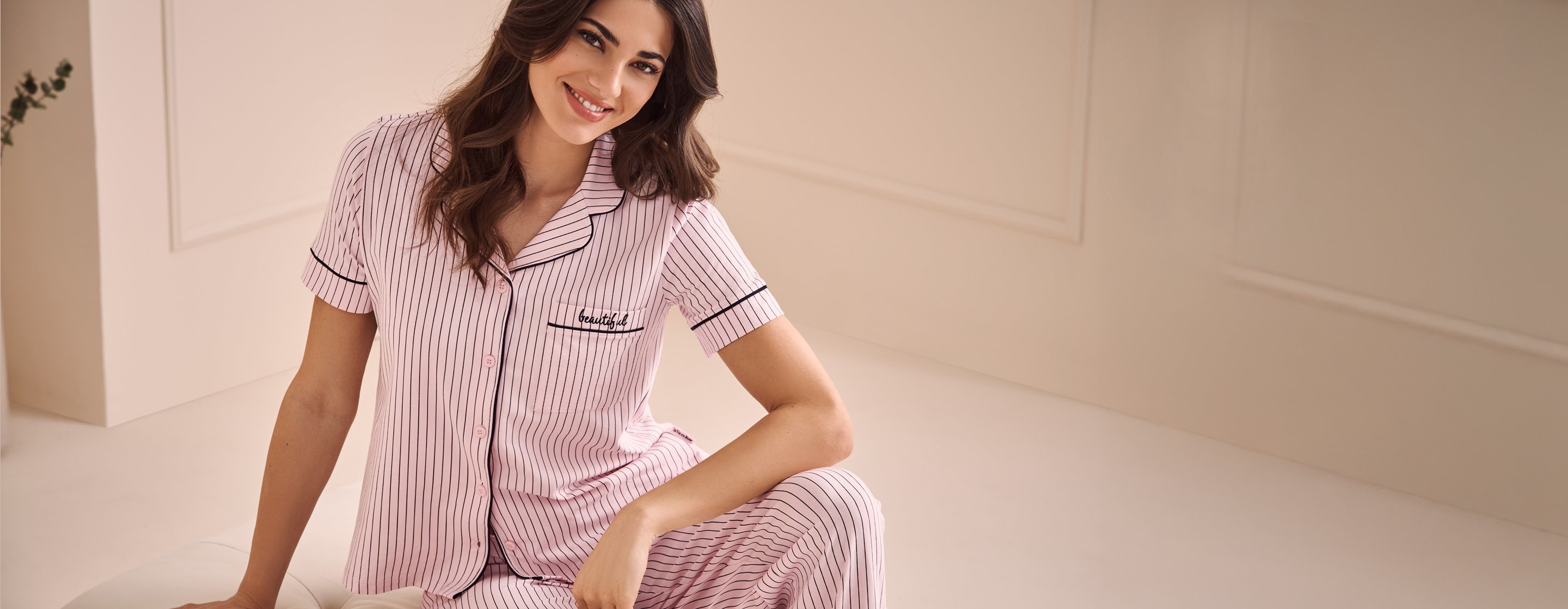 Model in pink striped cotton pyjamas, short-sleeve top and pants