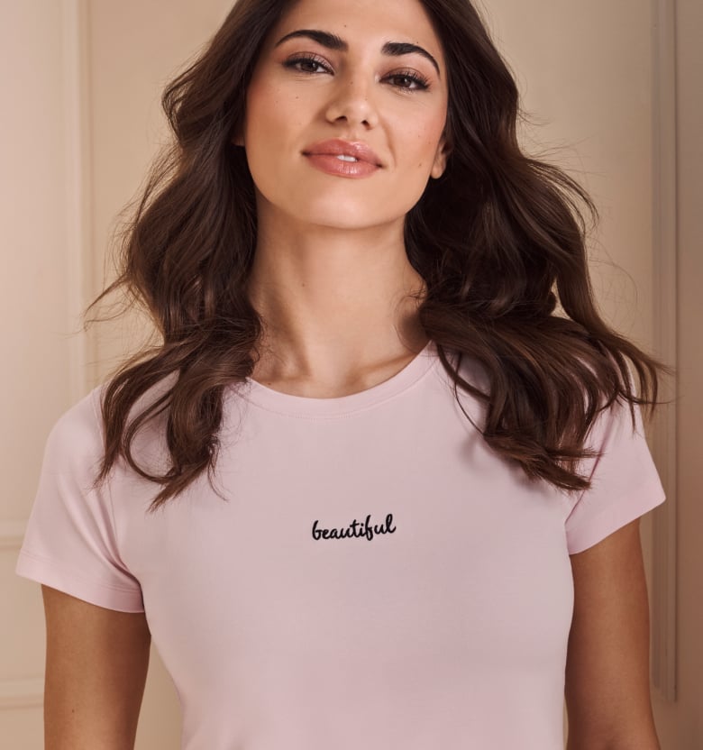 Model in pink striped cotton pyjamas, short-sleeve top and pants