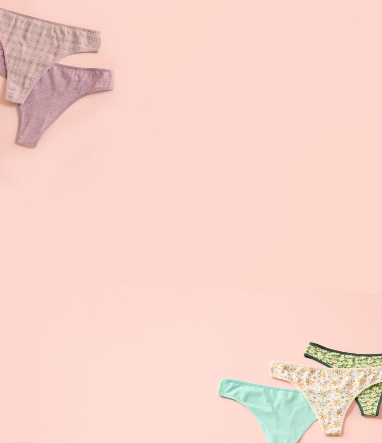 Panties in various colours and patterns laid out on a pink background.
