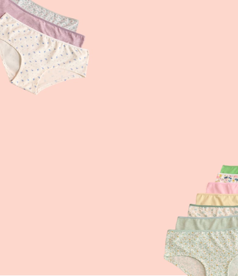Panties in various colours and patterns laid out on a pink background.