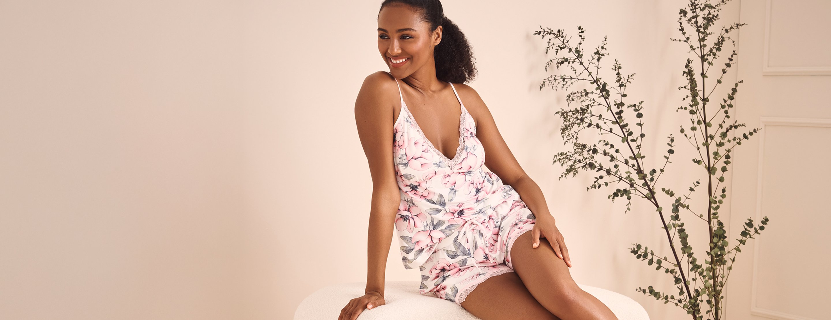 Model in white camisole and shorts with pale pink floral print