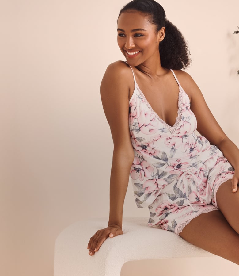 Model in white camisole and shorts with pale pink floral print