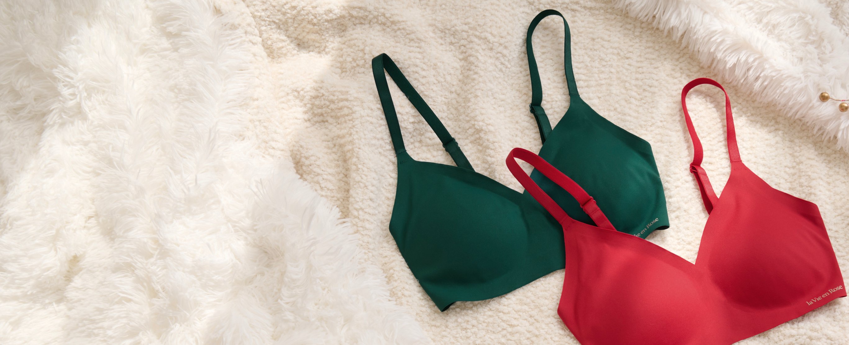 Two lounge bras lying on a blanket, one red, the other green.