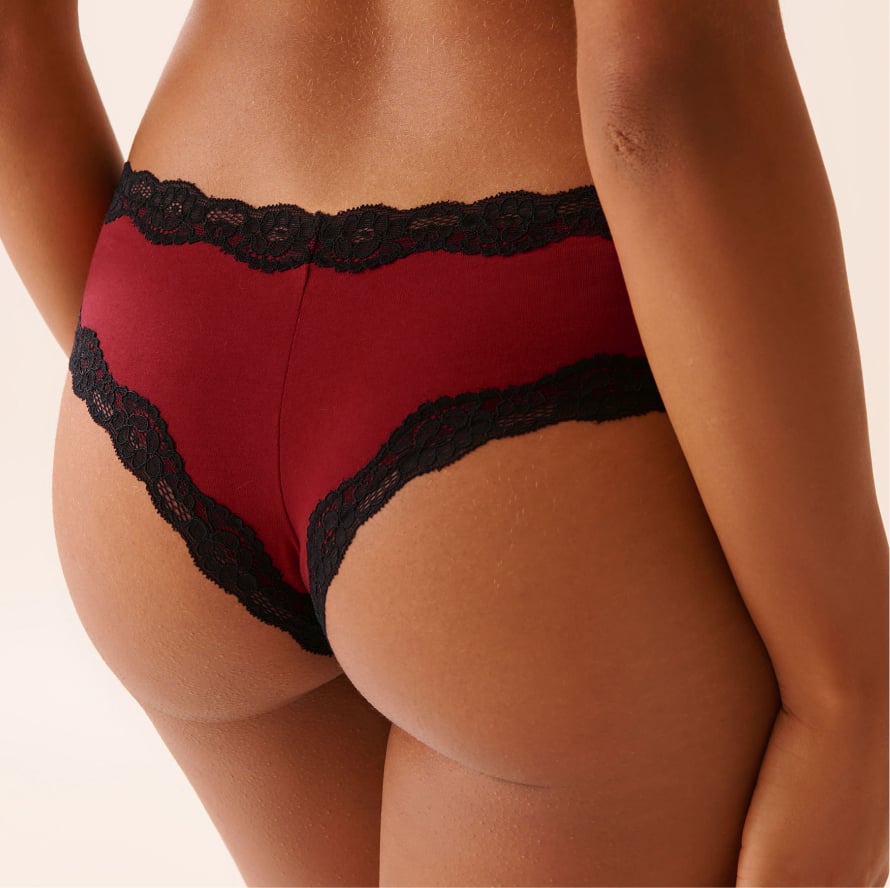 Back view of model wearing burgundy panties with black lace trim.