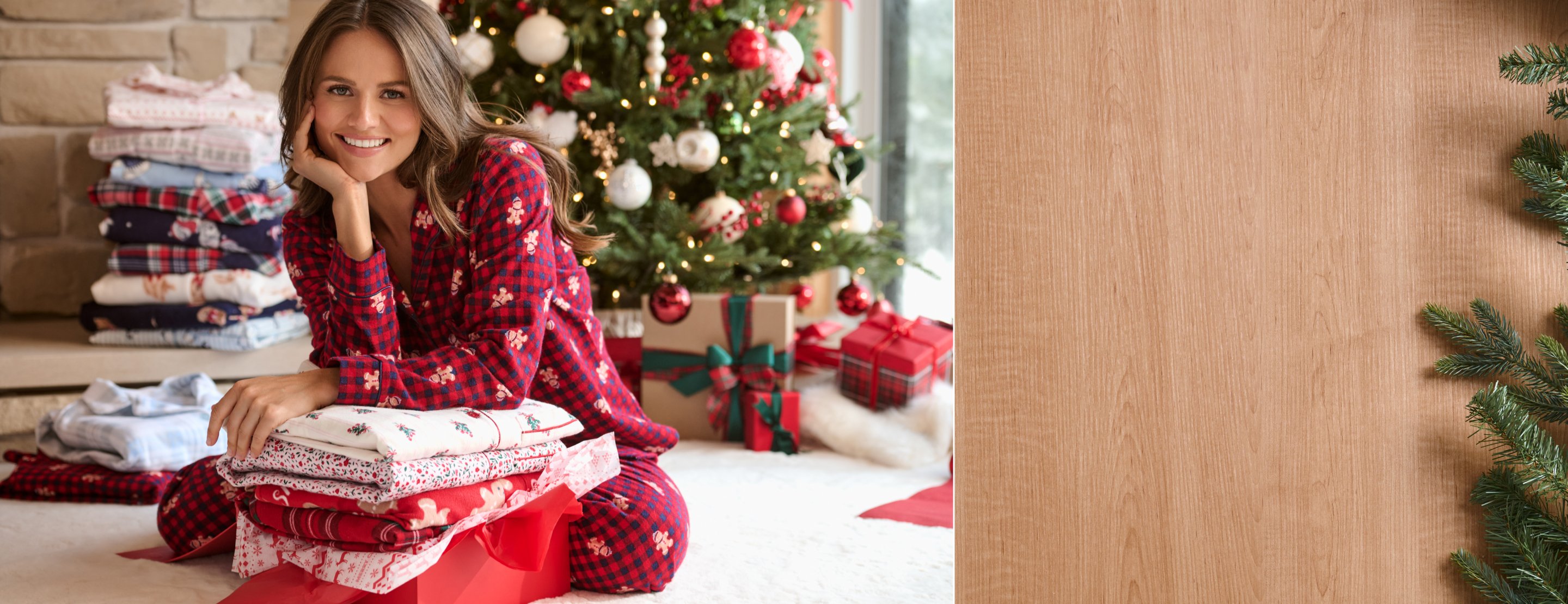 Model wearing red plaid pajamas with small gingerbread man prints.