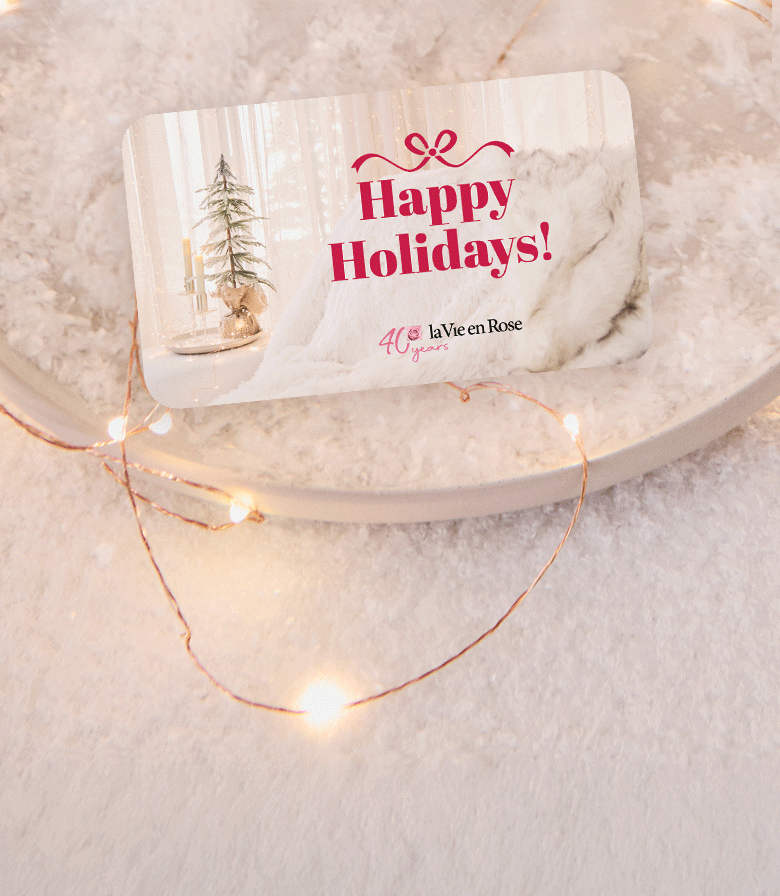 GIF of La Vie en Rose gift cards stacking on snowy background with festive lights