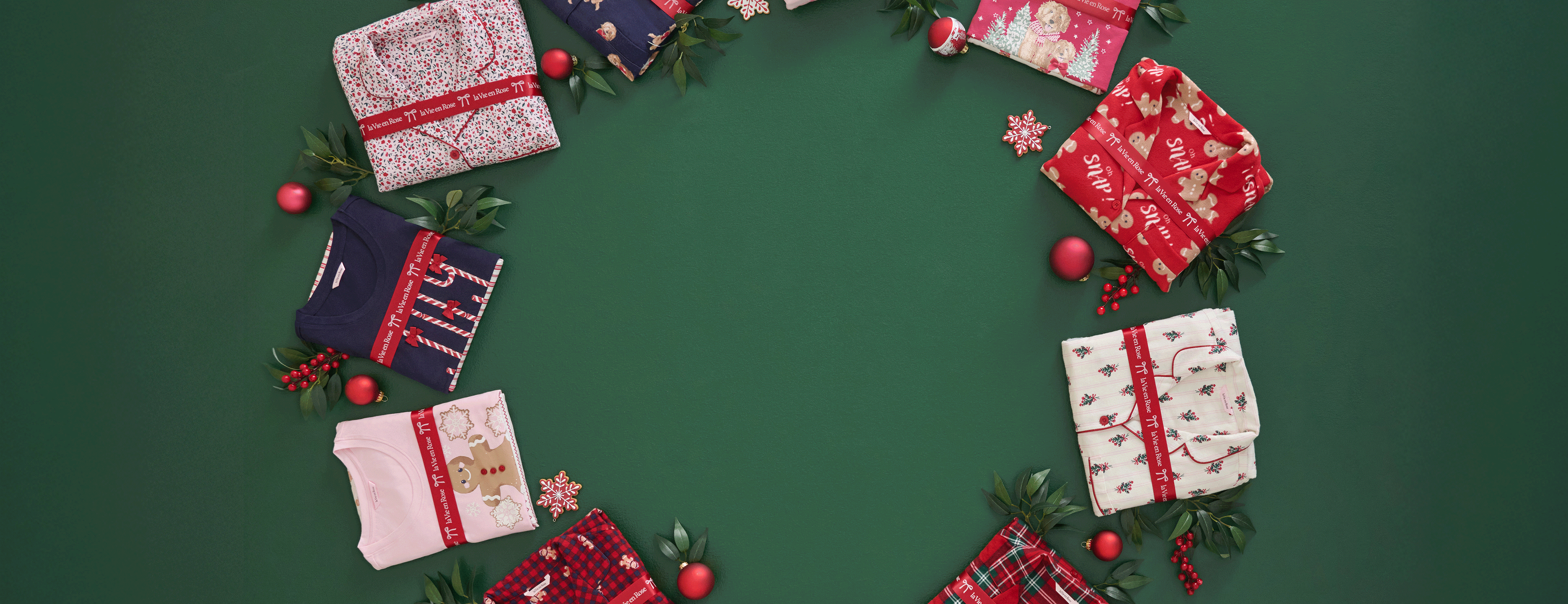 Folded pajama sets with festive prints arranged in a circle on green background, 2-for-1 offer