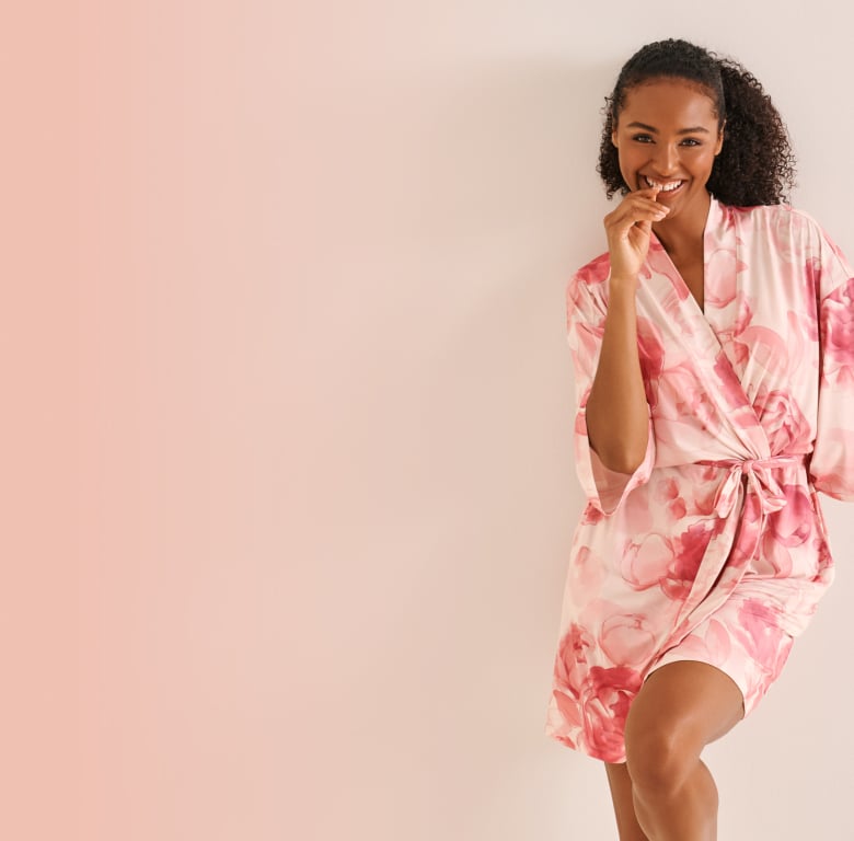 Model wearing a pink floral bra and panty set with a matching kimono, featured in a promotional banner
