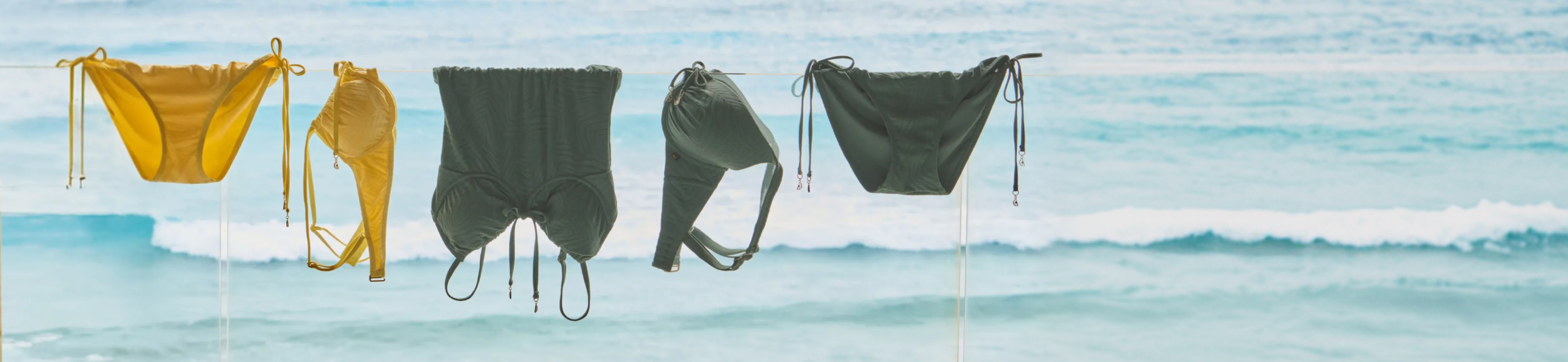 yellow and green swimsuits hanging by the sea