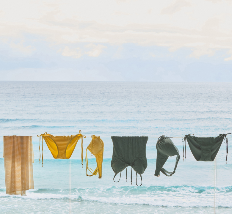 yellow and green swimsuits hanging by the sea