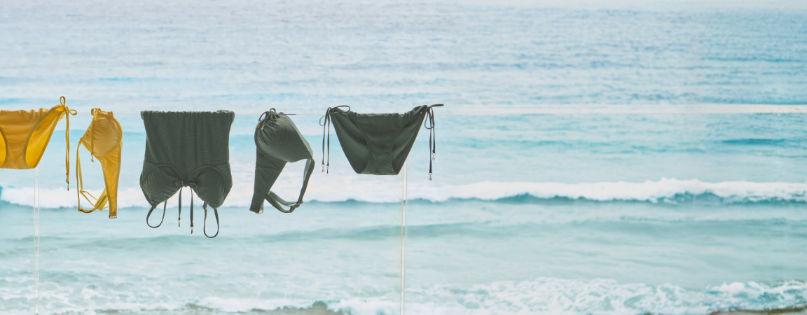 yellow and green swimsuits hanging by the sea