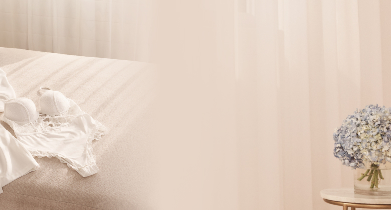 Kimono satin&eacute; blanc et combin&eacute; en dentelle blanc pos&eacute;s sur un sofa