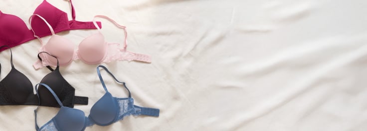Four laid-out bras: dark pink, light pink, blue, and black.