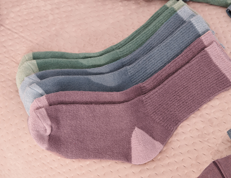 three pairs of socks: one blue, one pink, and one green