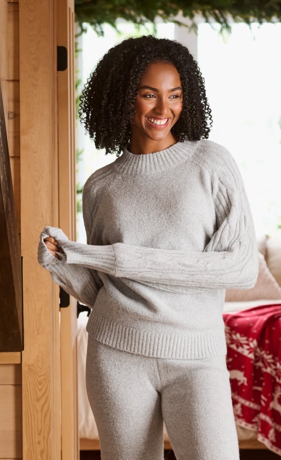 Model wearing a gray knit loungewear sweater.