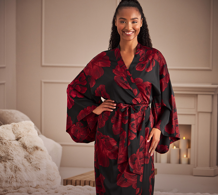 Model wearing a black satin robe with red flowers