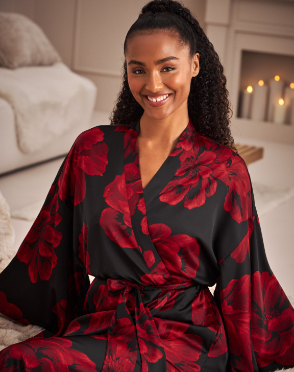 Model wearing a black satin robe with red flowers