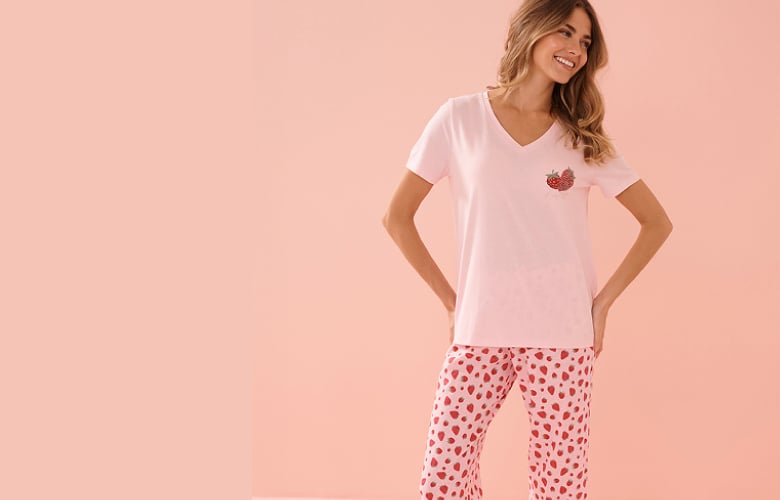 Model in light pink t-shirt with a strawberry on the chest and matching strawberry-print capris.