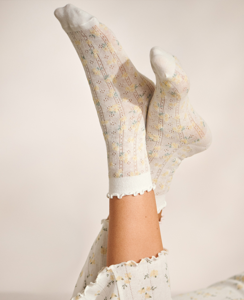 Model wearing white pointelle socks with yellow flowers