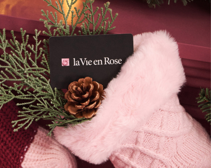 Gift card in a pink stocking hanging from a fireplace