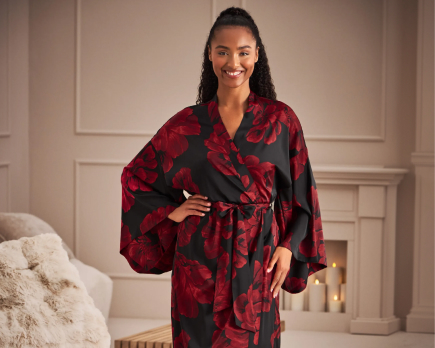 Model wearing a black satin kimono with red flowers