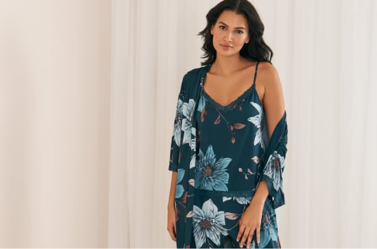 Model in blue floral camisole and pants with matching kimono featuring white floral patterns.