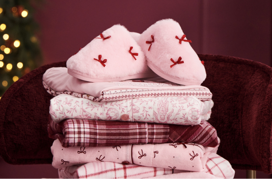 A stack of pale pink pajamas and slippers