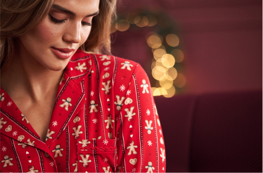 Model wearing red pajamas with a gingerbread pattern