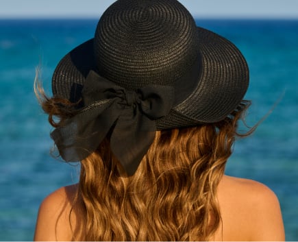 Black straw hat with black bow, seen from behind.