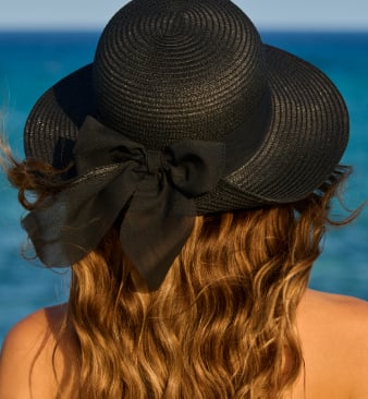 Black straw hat with black bow, seen from behind.