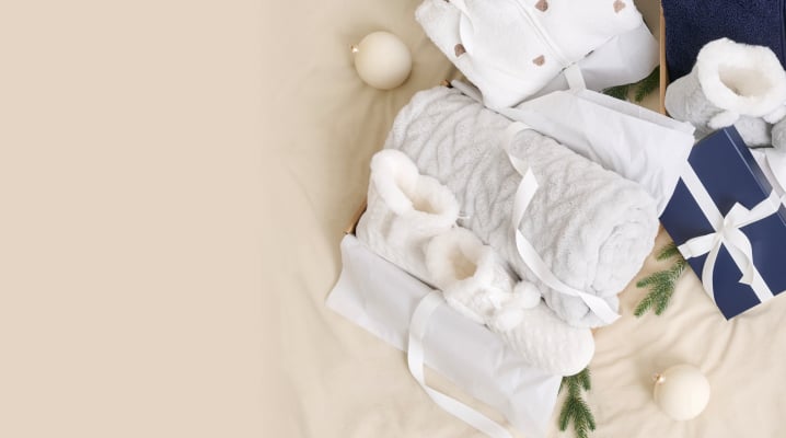 Accessoires cadeaux incluant couvertures, pantoufles et peignoirs soigneusement emballés.