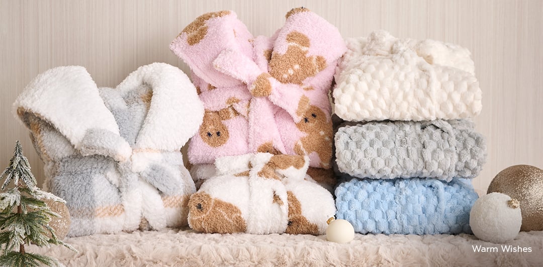 Plush bathrobes in soft tones, folded or tied.