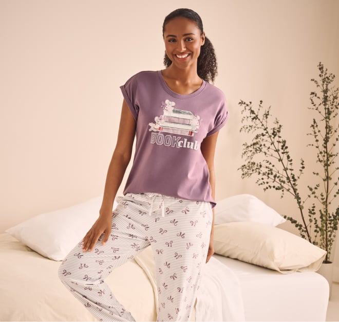 Model wearing cotton pyjamas: purple top and patterned white pants.