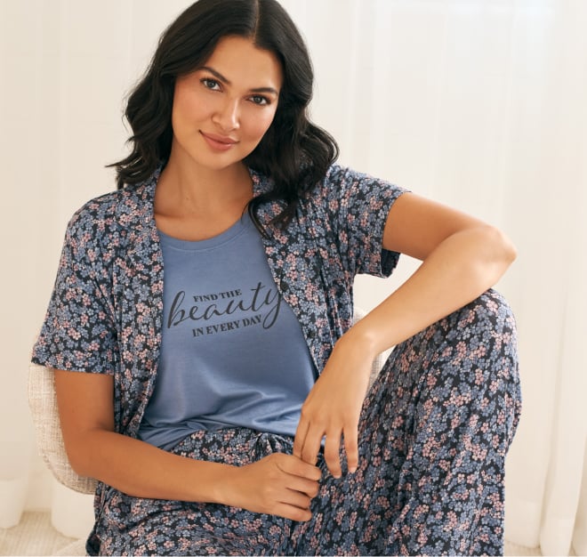 Model wearing cotton pyjamas: purple top and patterned white pants.