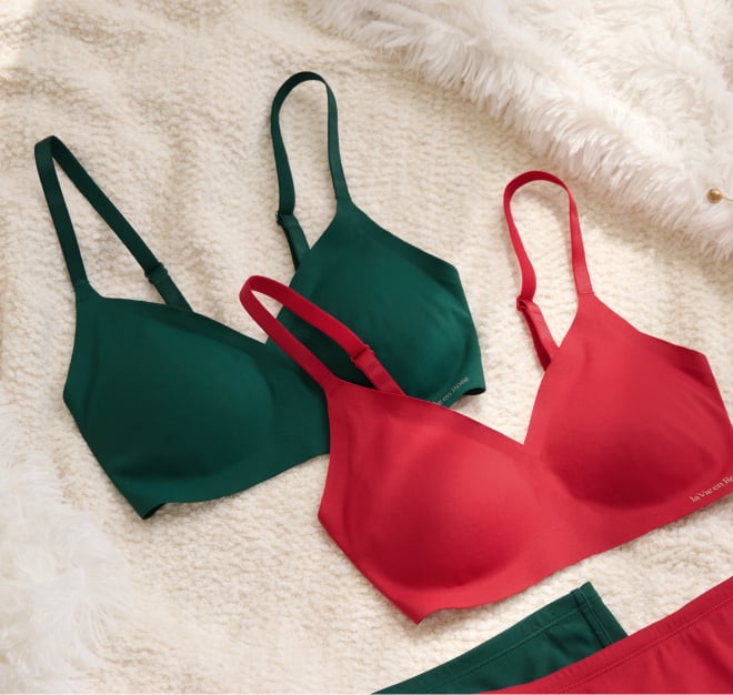 Two lounge bras lying on a blanket, one red, the other green.