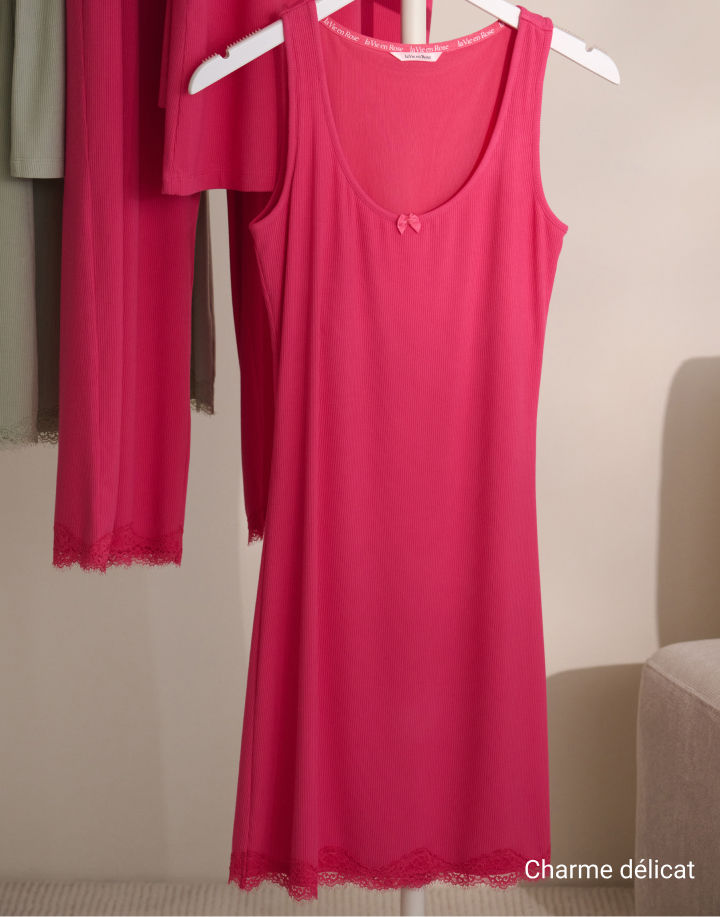 Mannequin de dos portant un body rose texturé avec un grand nœud à la taille et un dos ouvert.